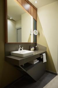 a bathroom with a sink and a mirror at Mercure Saransk Center in Saransk