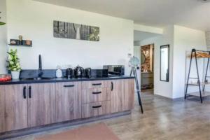 uma cozinha com armários de madeira e um tripé em Suite Belmondo - 4P - Proche Disney em Montry