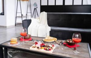 uma mesa com comida e dois copos de vinho em Suite Belmondo - 4P - Proche Disney em Montry