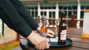 two bottles of beer on a table with glasses at Beechlawn Hotel in Belfast