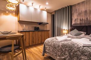 a hotel room with a bed and a desk at Apartamenty Jedlina in Zakopane