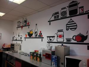 a kitchen with shelves on the wall with appliances at Hotel La Curva in Albolote