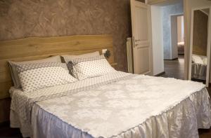 a bedroom with a large bed with white sheets and pillows at La Maison Apartment in Fanano
