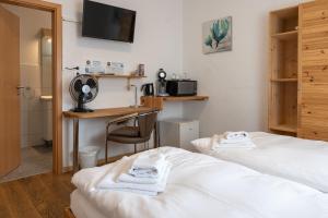 a hotel room with two beds and a desk at Gästehaus Neckarsulm in Neckarsulm