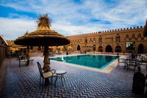 um pátio com uma piscina com um guarda-sol em Kasbah Hotel Ziz Palace Rissani em Rissani