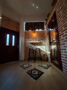 a living room with a brick wall and a stool at Relax Inn in Korçë