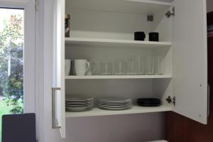 a kitchen shelf with plates and cups and dishes at Apartment Spring Creek in Merseburg