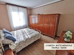 una camera con letto e armadio in legno di Appartamento Campi Elisi a Trieste