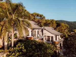 una casa en una colina con una palmera en Naatooh Guest Houses, en Florianópolis