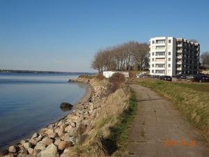 a building on the shore of a body of water at Ferienwohnung Pape in Glücksburg