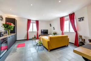 een woonkamer met een gele bank en rode gordijnen bij Suite Brooklyn - 6P - Proche Disney in Montry