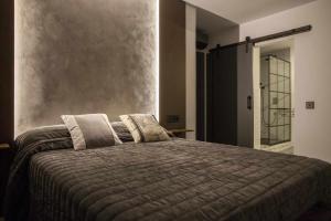 a bedroom with a large bed with two pillows at La Aduana - The Lodging Experience in Astorga