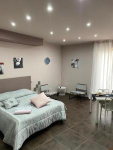 La casa di Francesca في Campobello di Licata: غرفة نوم بسرير وطاولة وكراسي