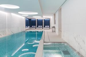 una piscina en una habitación de hotel con agua azul en The Woodward - an Oetker Collection Hotel en Ginebra