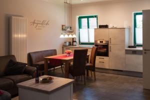 ein Wohnzimmer mit einem Tisch und einer Küche in der Unterkunft Auszeithof Otersen - Ferienwohnung 2 in Kirchlinteln