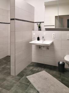 ein weißes Bad mit einem Waschbecken und einem WC in der Unterkunft Auszeithof Otersen - Ferienwohnung 2 in Kirchlinteln