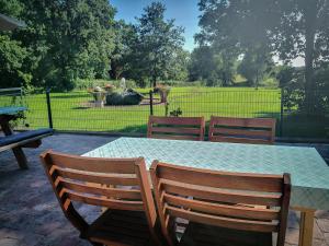 einen Tisch und Stühle mit einem Tisch und einem Zaun in der Unterkunft Auszeithof Otersen - Ferienwohnung 2 in Kirchlinteln