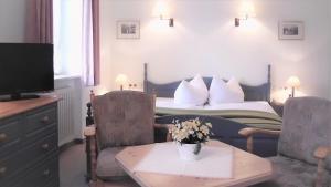 Hotel garni Floriani في بيرتشسغادن: غرفة في الفندق بها سرير وطاولة بها زهور