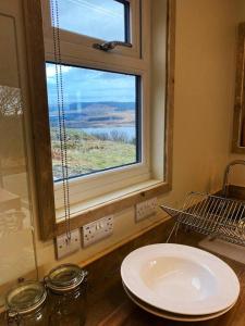 ein Bad mit einem Waschbecken und einem Fenster in der Unterkunft Odhrán Lodge, St Conan's Escape: Home with a view in Loch Awe