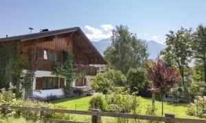 a house in a garden with mountains in the background at Apartment Ilishof in Schruns-Tschagguns
