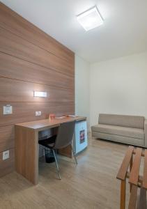 a office with a desk and a couch in a room at Hotel Glória in Blumenau