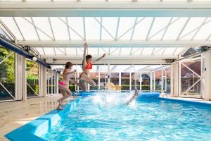 two girls jumping into a swimming pool at TopParken - Resort Veluwe in Garderen