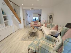 a living room with couches and a table at Jan Dee Cottage in Ventnor