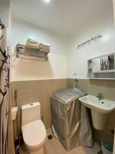 a bathroom with a toilet and a sink at Cozy 1 BR Apartment At South Residences Tower 2 in Manila