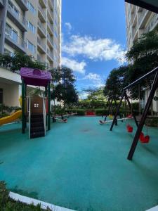 un parco giochi vuoto con scivolo e altalene di A Cozy 1 Bedroom Unit with a Parking at Tower 2 South Residences SM Southmall a Manila