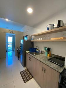 a kitchen with a refrigerator and a counter top at Cozy 1 BR Apartment At South Residences Tower 2 in Manila