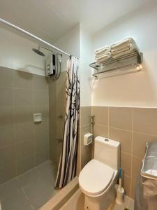 a bathroom with a toilet and a shower at Cozy 1 BR Apartment At South Residences Tower 2 in Manila