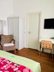 a room with a bed and a desk and a television at Via Padova 165 in Milan
