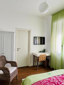 1 dormitorio con cama, escritorio y silla en Via Padova 165, en Milán