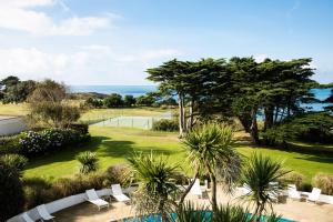 uitzicht op een tuin met een tennisbaan bij The Atlantic Hotel - Small Luxury Hotels of the World in St Brelade