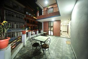 un patio con tavolo e sedie in un edificio di Karma Hotel Nepal a Kathmandu