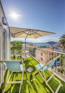 a balcony with a table and chairs and an umbrella at Cozy apartment in the heart of Mali Lošinj - 45 m² with view in Mali Lošinj