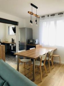 a kitchen with a wooden dining table and chairs at Ar Mor, votre pied à terre cocoon au cœur de ville in Paimpol