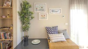 a living room with a chair and a plant at Cozy apartment in the heart of Mali Lošinj - 45 m² with view in Mali Lošinj