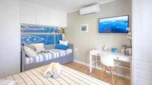 a bedroom with a bed and a desk and a tv at Cozy apartment in the heart of Mali Lošinj - 45 m² with view in Mali Lošinj