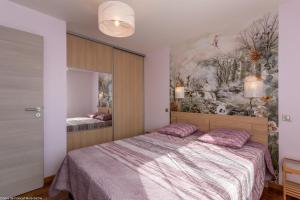 ein Schlafzimmer mit einem Bett und einem Wandgemälde in der Unterkunft Les Bords de Saône in Rigny