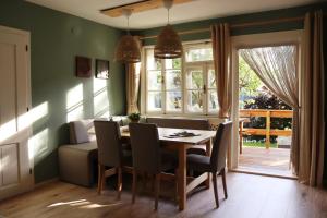 jadalnia ze stołem i krzesłami oraz oknem w obiekcie Villa Zeppelin - App Bergkristall w mieście Bramberg am Wildkogel