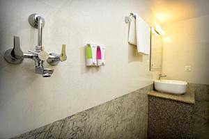 un bagno con lavandino, specchio e asciugamani di Karma Hotel Nepal a Kathmandu