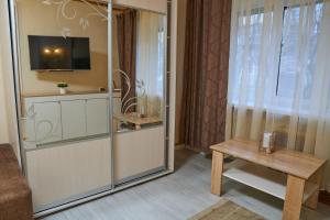 a room with a glass partition with a table and a tv at Центр 1-поверх жалюзі на вікнах кондицioнер wifi in Ivano-Frankivsʼk