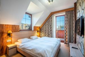 ein Schlafzimmer mit einem großen Bett in einem Zimmer mit Fenstern in der Unterkunft Kukučka Lomnica - Tatranská Lomnica in Tatranská Lomnica