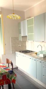 レヴァントにあるMartino Appartamentoのキッチン(白いキャビネット、コンロ付)