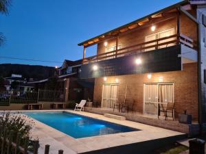 a house with a swimming pool in front of it at BAHIA DEL LAGO in Villa Carlos Paz