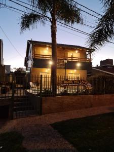 a house with a palm tree in front of it at BAHIA DEL LAGO in Villa Carlos Paz