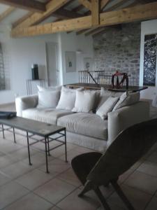 a living room with a white couch and a table at La Maison Du Ruisseau in Conilhac-Corbières