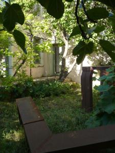 Conilhac-CorbièresにあるLa Maison Du Ruisseauの建物前の芝生に腰掛けたベンチ