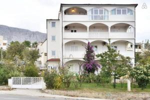 un grande edificio bianco con dei fiori di fronte di Apartment in Duce with sea view, balcony, air conditioning, WiFi 5063-2 a Duće